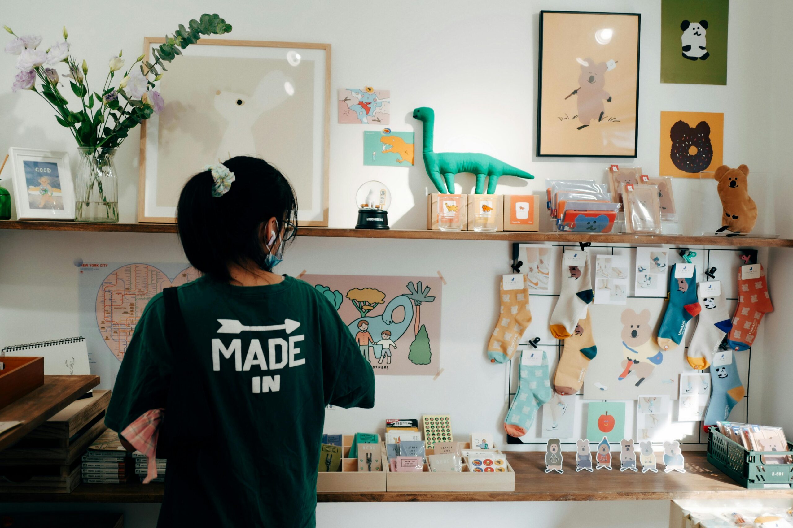 A vibrant interior of a gift shop displaying toys, socks, and wall decor, with a person browsing items.